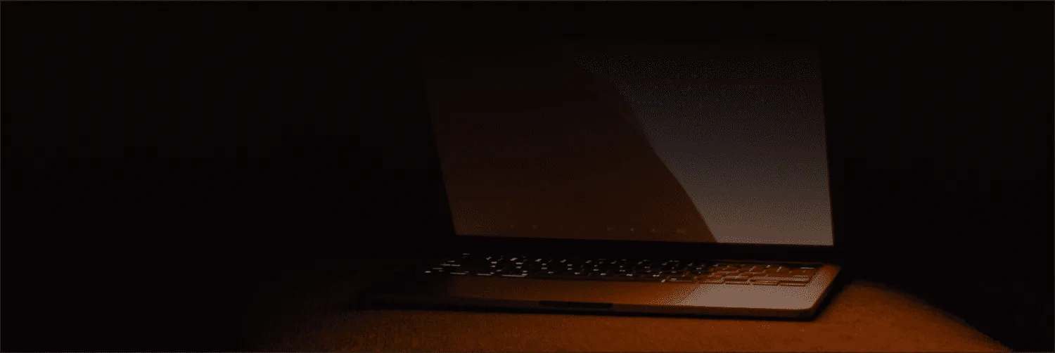 Laptop glowing in a dark room, identity theft prevention security tips